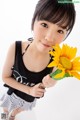 A young woman holding a sunflower in her hand.