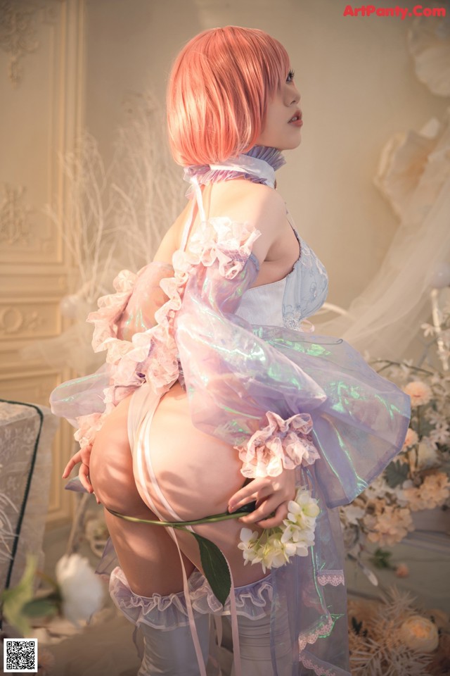 A woman with pink hair is posing for a picture.