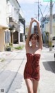 A woman in a red dress is walking down the street.