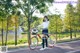 A woman in a school uniform standing next to a bike.