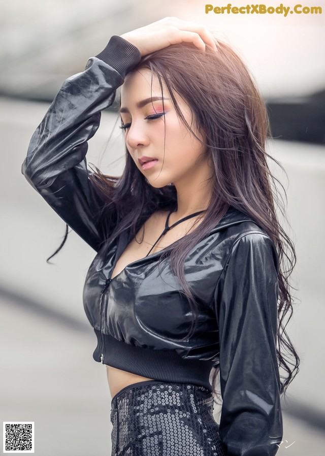 A woman in a black top and skirt posing for a picture.