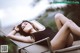 A woman in a black bathing suit laying on a lounge chair.