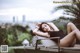 A woman in a black bathing suit laying on a lounge chair.