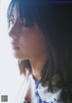 A woman with long hair looking out of a window.