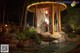 A gazebo in the middle of a pond at night.