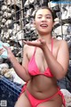 A woman in a pink bikini blowing bubbles.