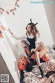 A woman sitting on top of a bed next to a bunch of balloons.